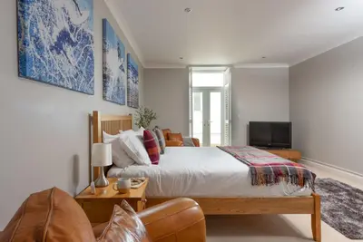 a bedroom with a large bed and a couch at 3 The Manor - Opposite a golf course - Pet friendly - Wi-Fi in Uny Lelant