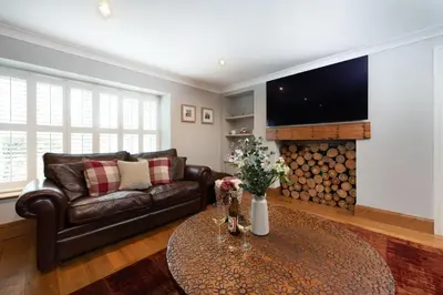 a living room with a leather couch and a table at 3 The Manor - Opposite a golf course - Pet friendly - Wi-Fi in Uny Lelant