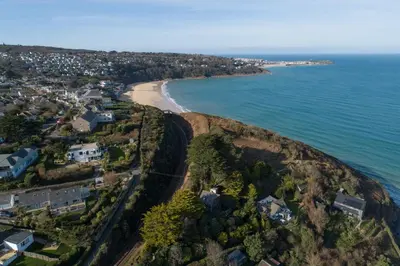 an aerial view of a beach with houses and the ocean at 3 The Manor - Opposite a golf course - Pet friendly - Wi-Fi in Uny Lelant