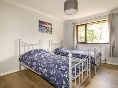 two beds in a bedroom with a window at Three Jays in Looe