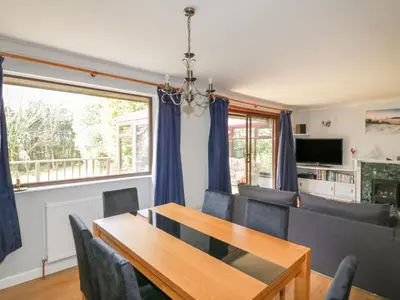 a dining room with a table and chairs and a window at Three Jays in Looe