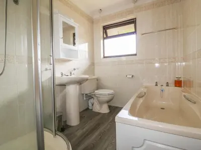 a bathroom with a tub and a toilet and a sink at Three Jays in Looe