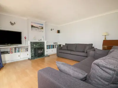 a living room with a couch and a fireplace at Three Jays in Looe