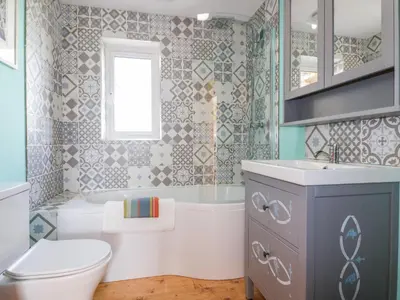 a bathroom with a toilet and a tub and a sink at Orchard Chalet in Liskeard