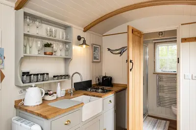 a kitchen with a sink and a counter top at Trevone Luxury Shepherds hut close to the beach in St Merryn