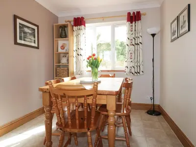 a dining room with a table and chairs and a window at Hazel Cottage in Tintagel