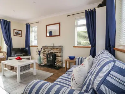 a living room with a couch and a fireplace at Hazel Cottage in Tintagel