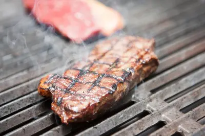 two pieces of meat cooking on a grill at Griffin Inn in Newquay