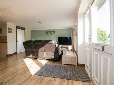 a living room with a couch and a television at Lower Brambleside in Truro