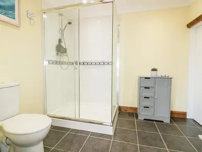 a bathroom with a shower and a toilet at Lower Brambleside in Truro