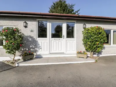 a house with a white door and two plants at Lower Brambleside in Truro