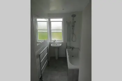 a bathroom with a tub and a sink and a bath tub at Lovely 3 Bed House Close to Carlyon Bay Beach! in Carlyon Bay