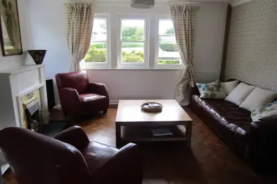 a living room with a couch and chairs and a table at Lovely 3 Bed House Close to Carlyon Bay Beach! in Carlyon Bay