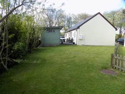 a yard with a white house and a fence at 2-Bed Cottage Sleeps 5 Pets Ok Close to Coast in Davidstow