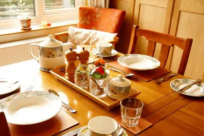 a table with plates and cups and a tray of food at The Dog House, Penryn in Penryn