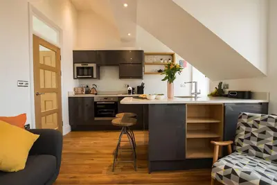 a kitchen with a kitchen island in a living room at Manderley Penthouse in St Ives