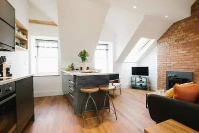 a kitchen with a island in the middle of a living room at Manderley Penthouse in St Ives