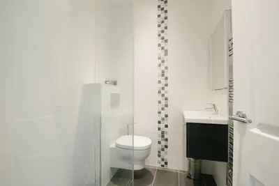 a white bathroom with a toilet and a sink at Harbour Vista in St Ives