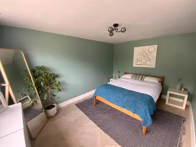 a bedroom with a bed and a green wall at Little Chi in Truro