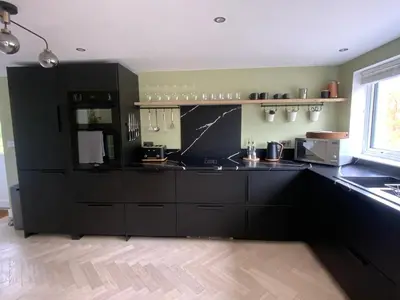 a kitchen with black cabinets and a counter top at Little Chi in Truro