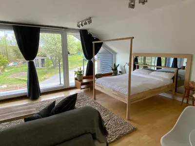 a bedroom with a bed and a large window at Little Chi in Truro