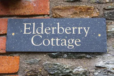 a sign that says elderberry coffee on a brick wall at Polrunny Farm Elderberry Cottage with sea view in Boscastle
