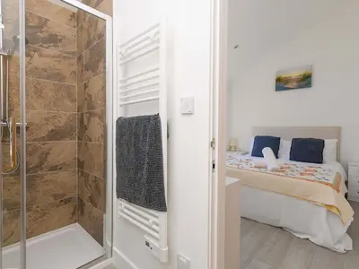 a small bedroom with a bed and a shower at Mellydonen Beder Del Melly, Tor Down Quarry in Bodmin
