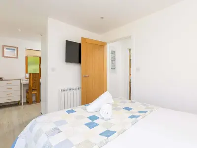 a bedroom with a bed and a tv on the wall at Mellydonen Beder Del Melly, Tor Down Quarry in Bodmin