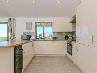 a kitchen with white cabinets and a wooden counter top at Mellydonen Beder Del Melly, Tor Down Quarry in Bodmin