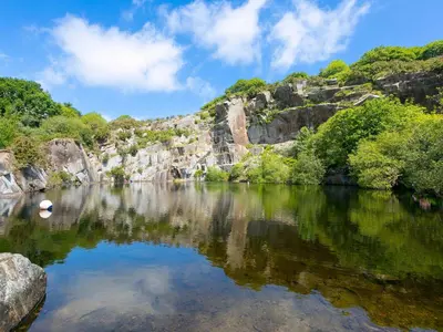 a body of water with trees and rocks at Mellydonen Beder Del Melly, Tor Down Quarry in Bodmin