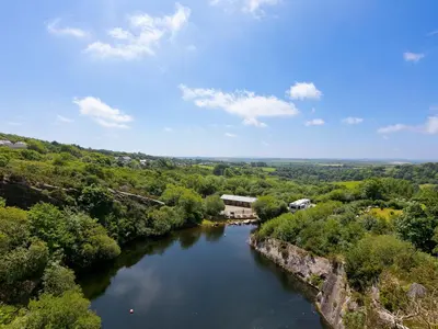 an aerial view of a river with trees at Mellydonen Beder Del Melly, Tor Down Quarry in Bodmin