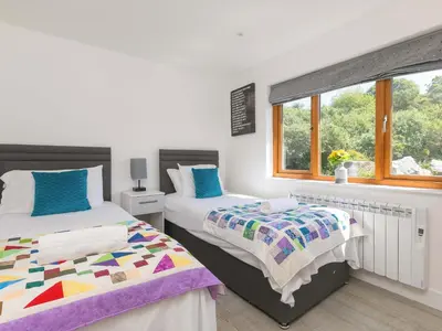 a bedroom with two beds and a window at Mellydonen Beder Del Melly, Tor Down Quarry in Bodmin