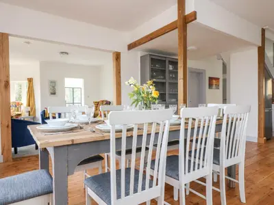 a kitchen and dining room with a wooden table and chairs at Dovefields in Helston