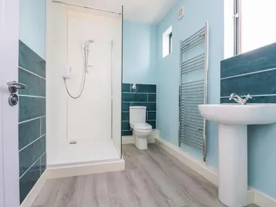 a bathroom with a shower and a sink and a toilet at Dovefields in Helston