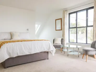 a bedroom with a bed and a table and a chair at Dovefields in Helston