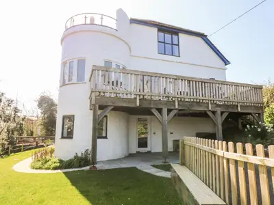 a white house with a deck on top of it at Dovefields in Helston