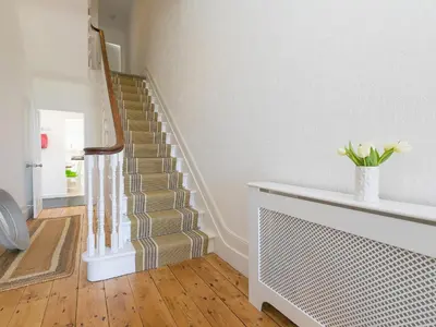 a staircase in a house with a vase of flowers at 6 Albany Terrace in St Ives