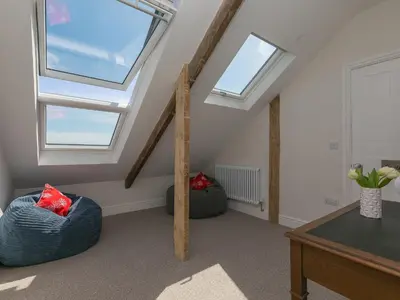 a attic room with skylights and a table and chairs at 6 Albany Terrace in St Ives