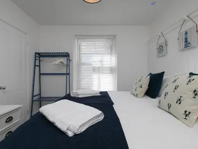 a bedroom with a large white bed and a window at 6 Albany Terrace in St Ives
