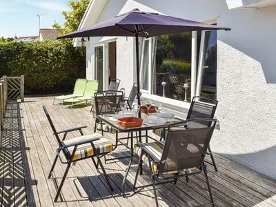 a table and chairs with an umbrella on a patio at Top Deck - Ancient Fishing Village - Near to the Beach! in Gorran Haven