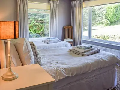 two beds in a room with a window at Top Deck - Ancient Fishing Village - Near to the Beach! in Gorran Haven