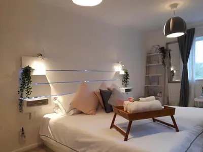 a bedroom with a large white bed with a table on it at Sunny-side-up in St Austell