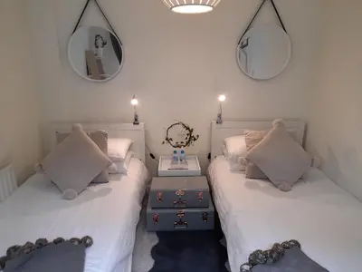 a bedroom with two beds and a mirror on the wall at Sunny-side-up in St Austell