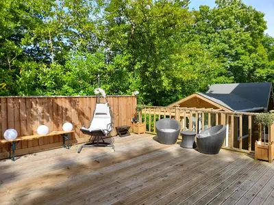 a deck with a bench and chairs on it at Sunny-side-up in St Austell