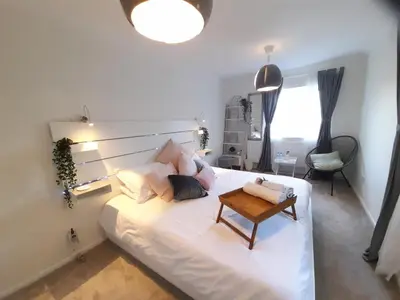 a bedroom with a white bed with a table on it at Sunny-side-up in St Austell