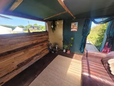 a room with a couch and a large window at The Paddock Wildcamp in Perranporth