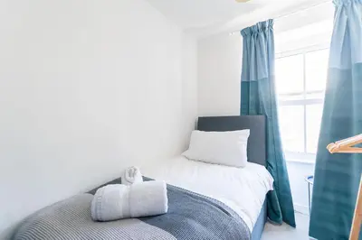 a bedroom with a bed with a teddy bear on it at Picture House in St Ives