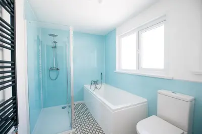 a bathroom with a toilet and a glass shower at Picture House in St Ives