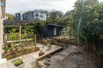 a garden with potted plants and a house at Primrose Cottage in St Ives