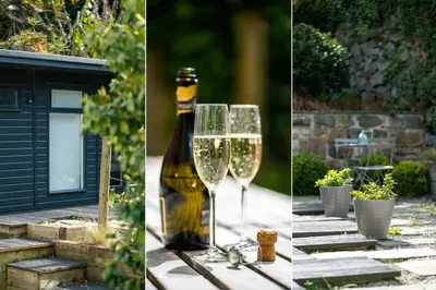 a bottle of wine and two glasses on a table at Primrose Cottage in St Ives